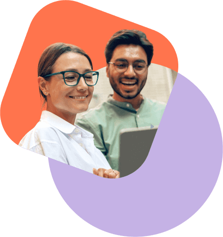 Two colleagues smile at a tablet together