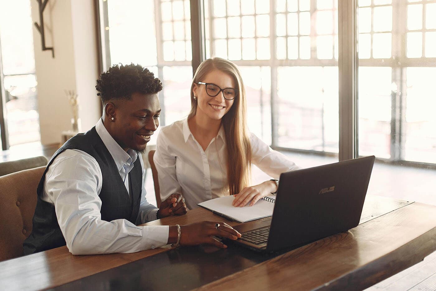 Mentor and mentee reviewing a mentoring program together on a laptop