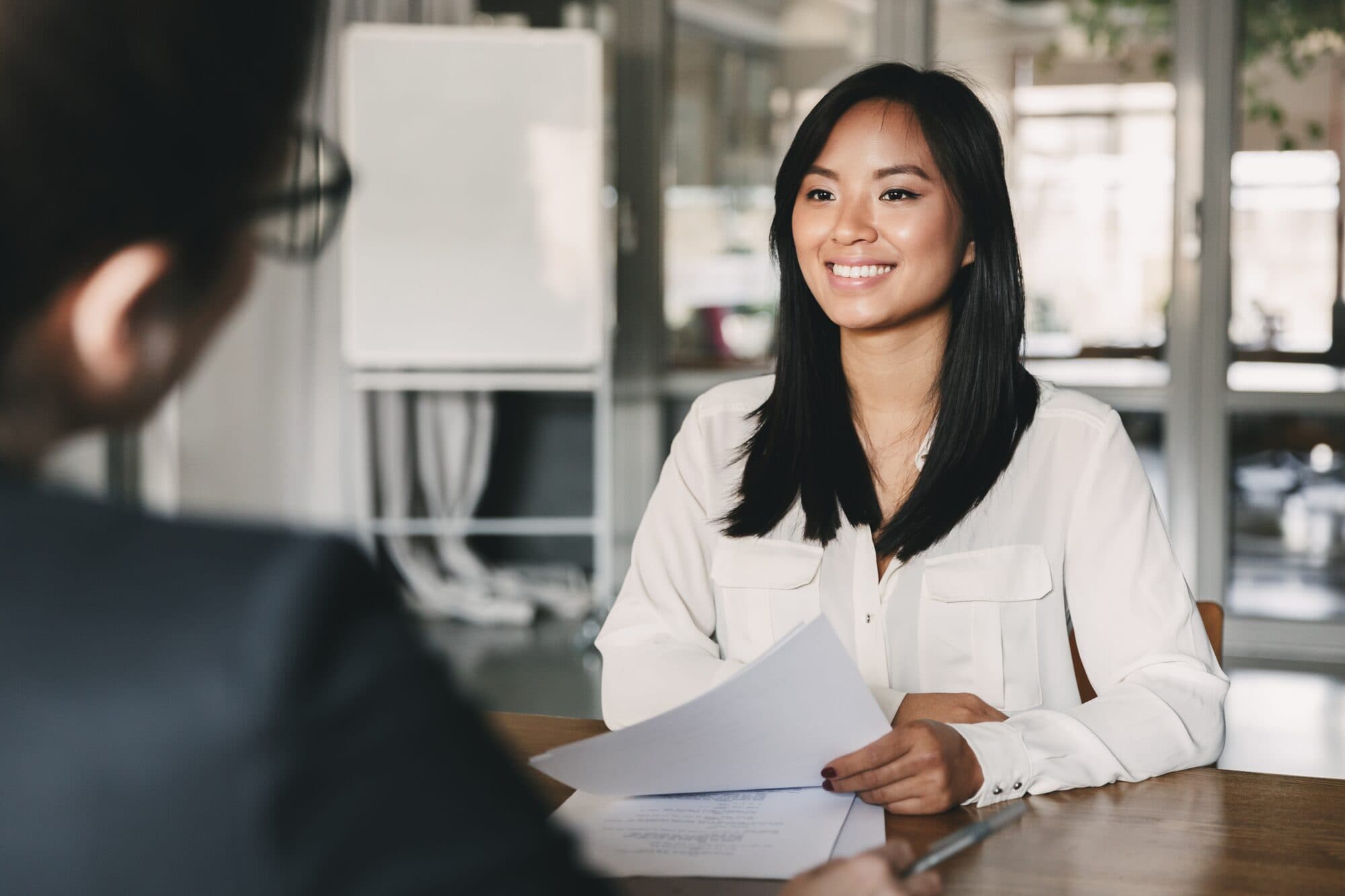 A candidate smiles across the table in an interview