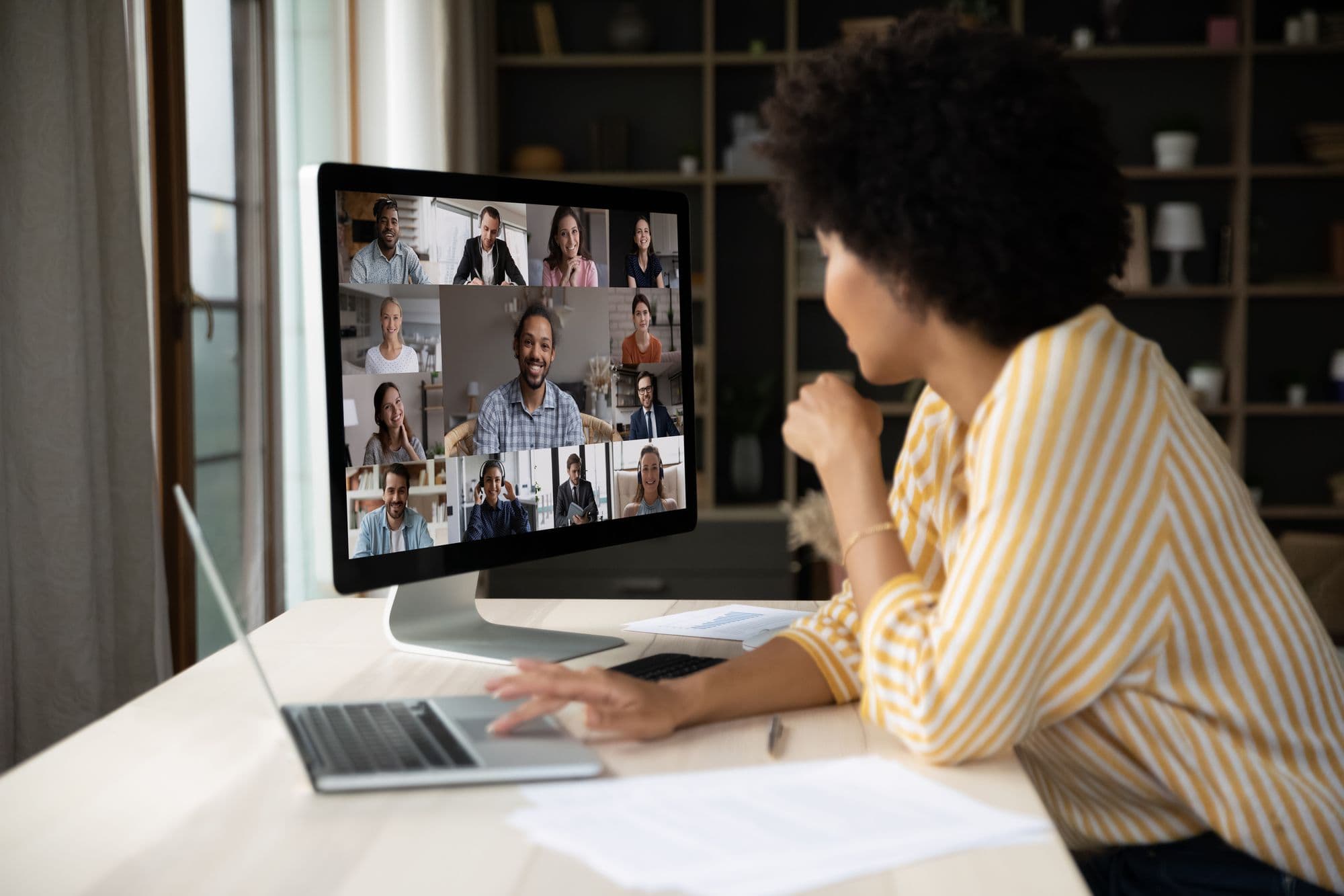 A woman talks with her community on a group video call