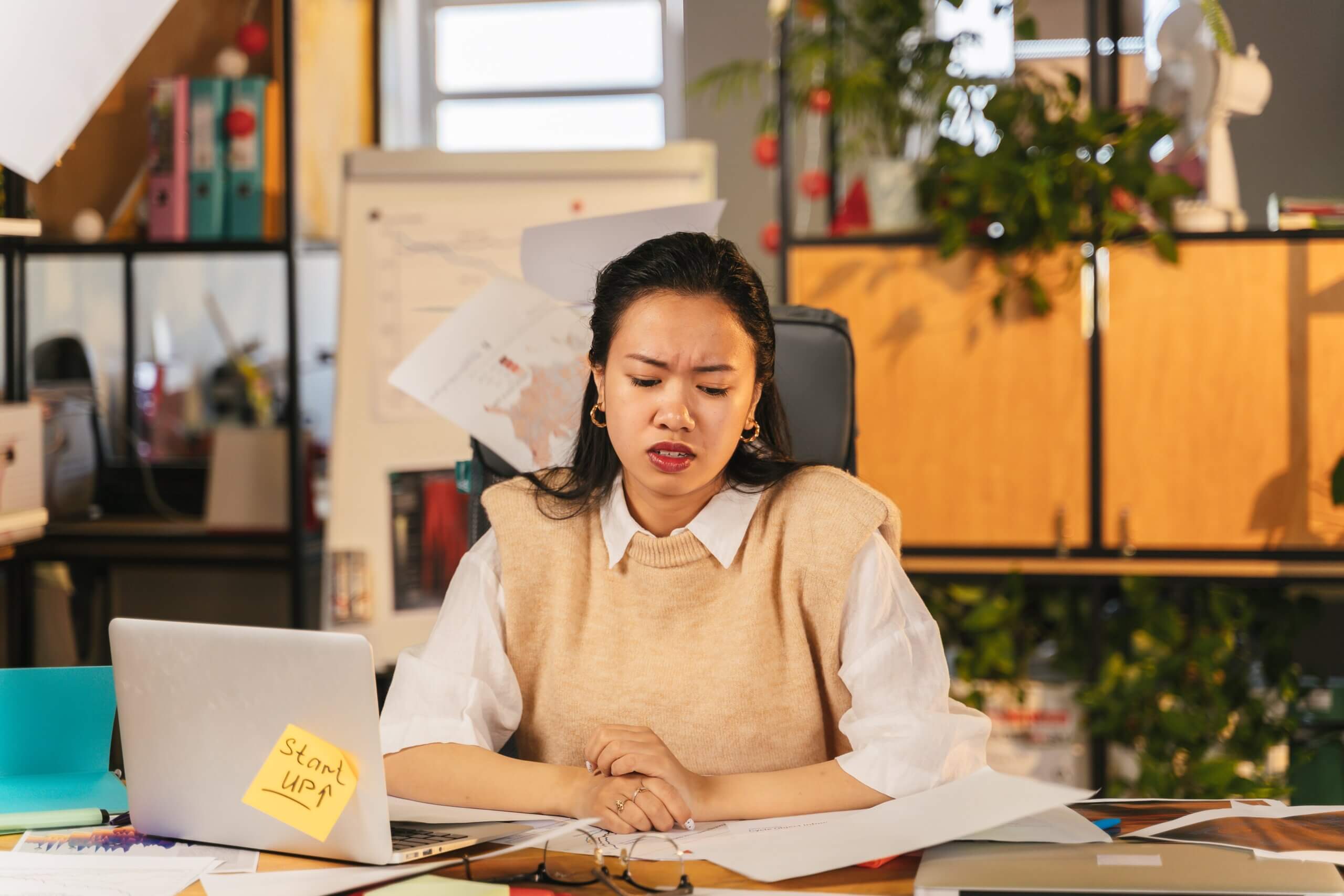 Frustrated employee working alone at her desk