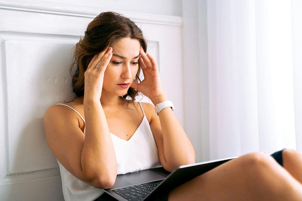 woman looking at her computer with her hands on her head after a frusrating mentoring meeting