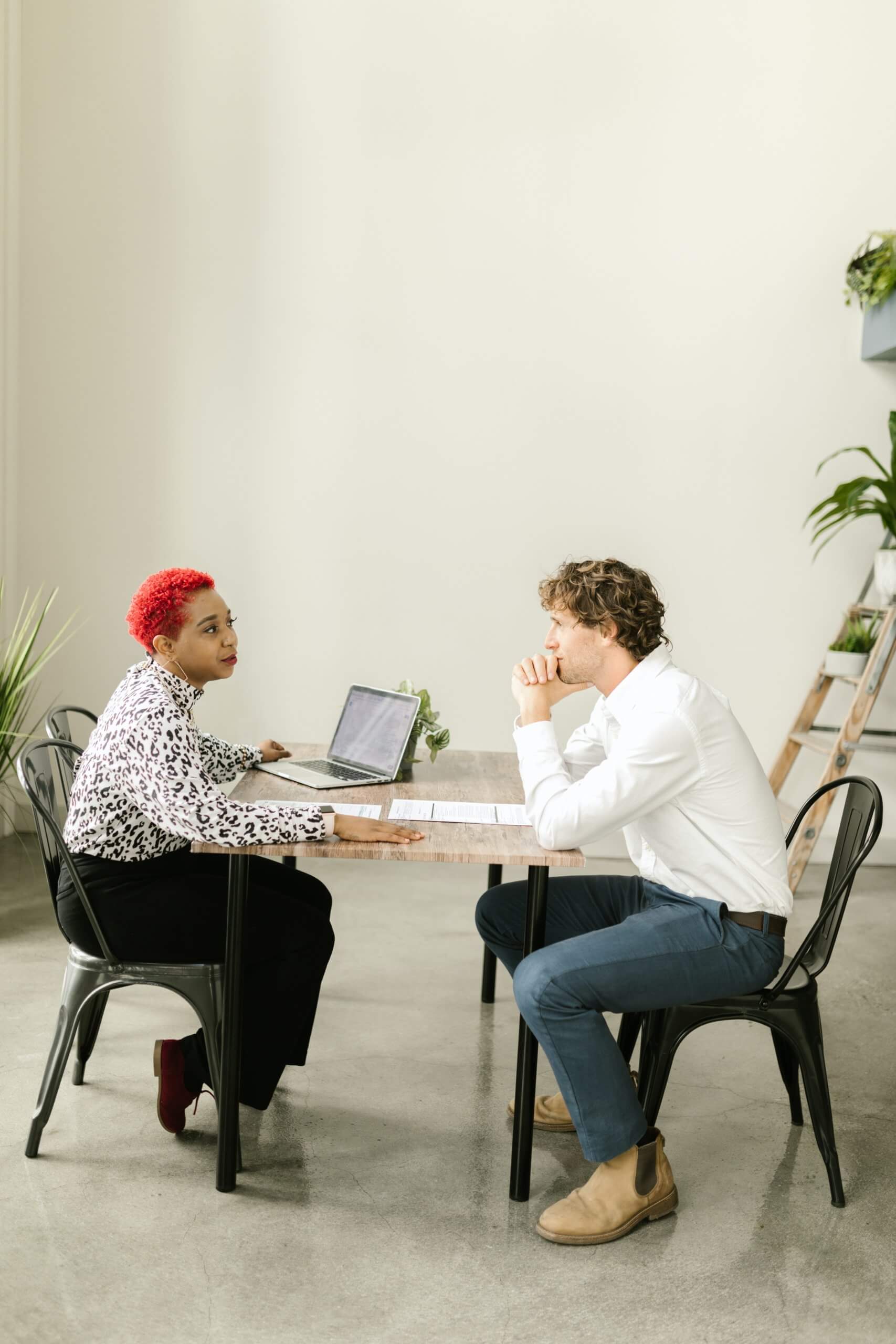 female manager and male direct report sitting at table discussing career pathing in organization
