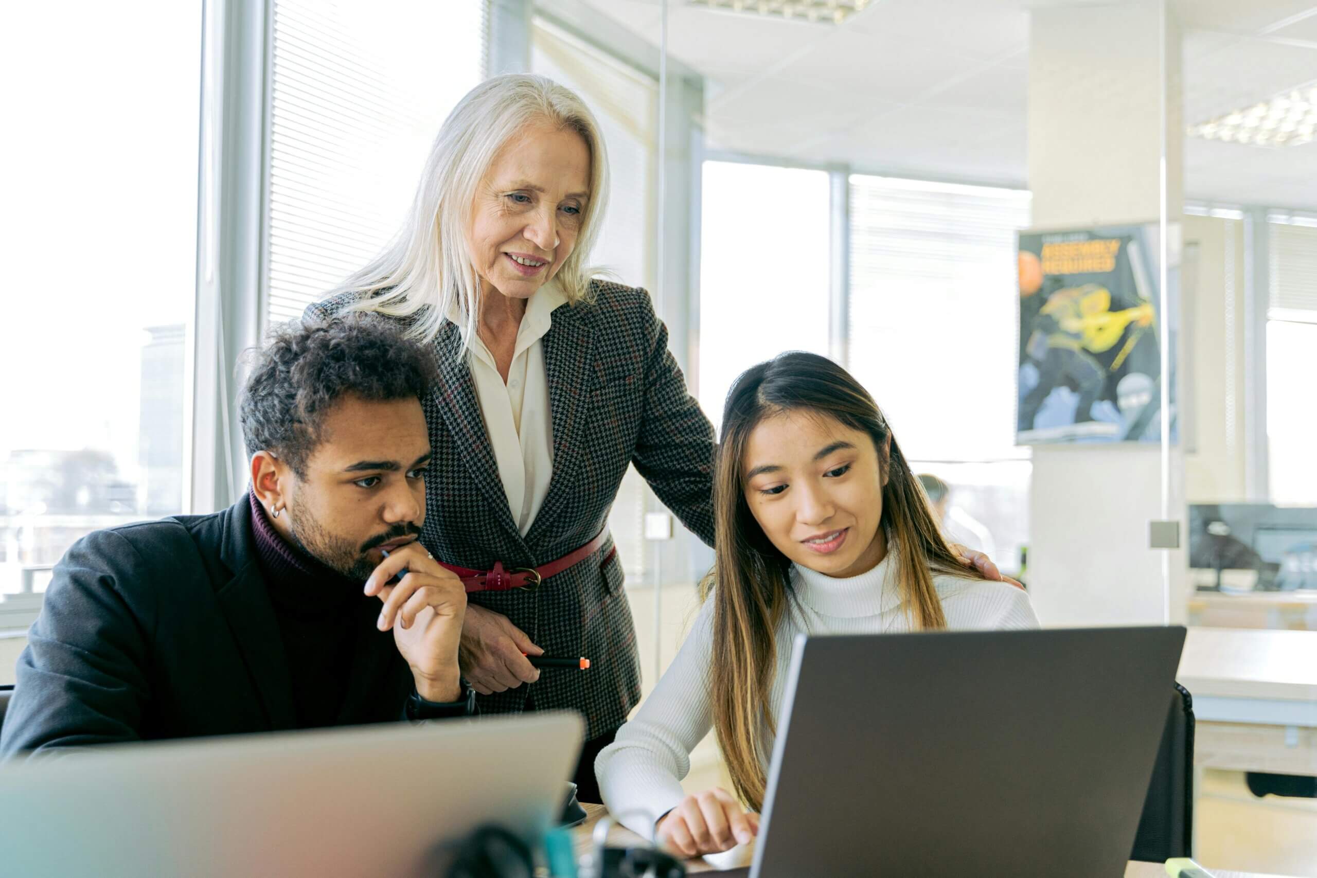 Colleagues reviewing work on a laptop together
