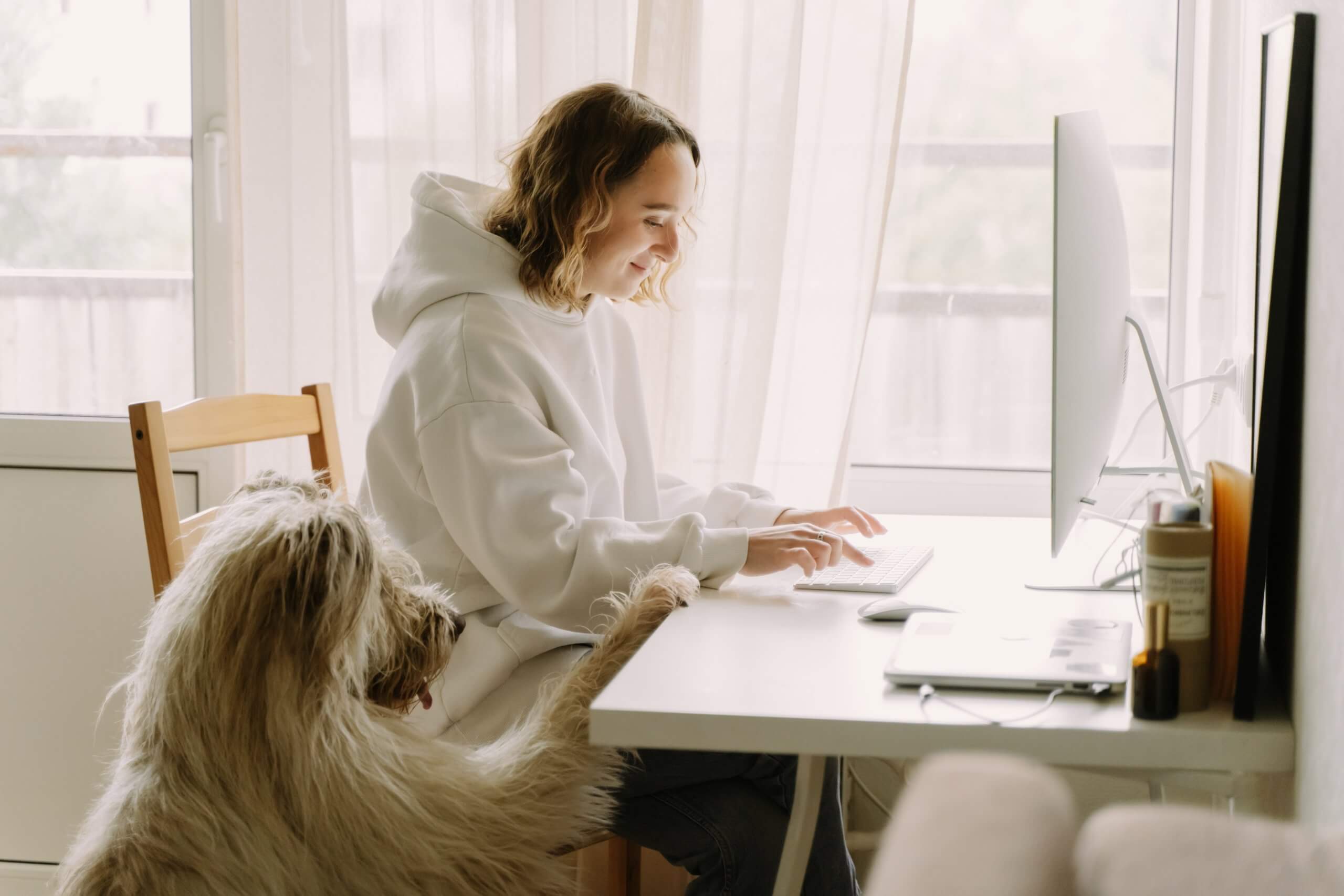 workplace trend: employee flexibility, woman working from home with her dog