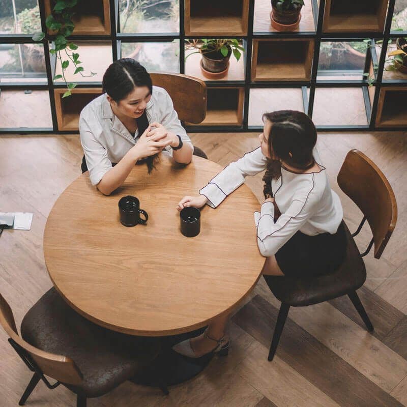 female coworkers in a coffee shop discussing matching mentors and mentees effectively