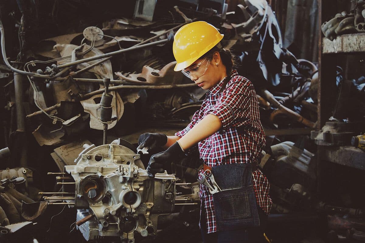 woman in a hard hat working on machinery motivate by her work