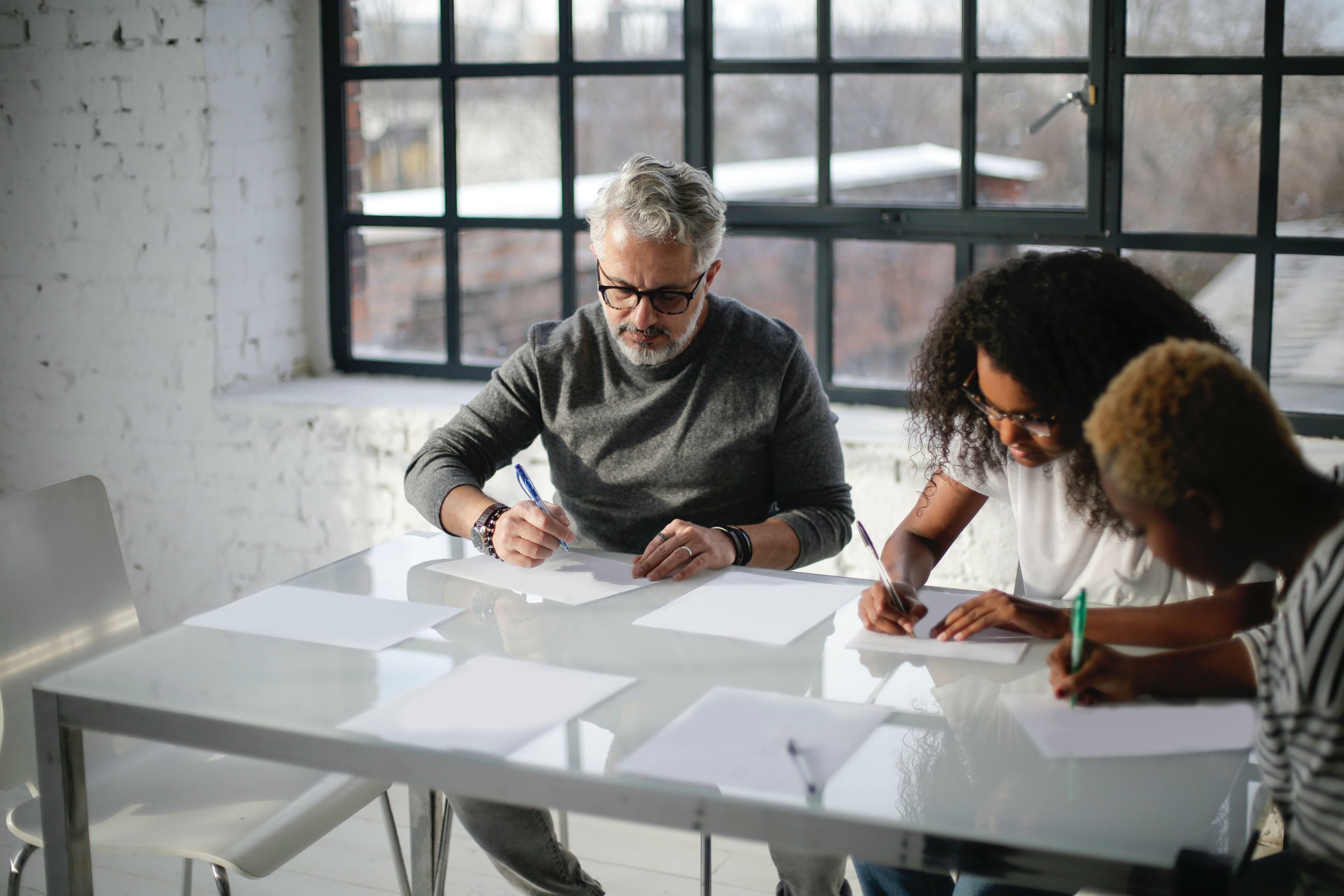 white male colleague working in a conference room with black female employees