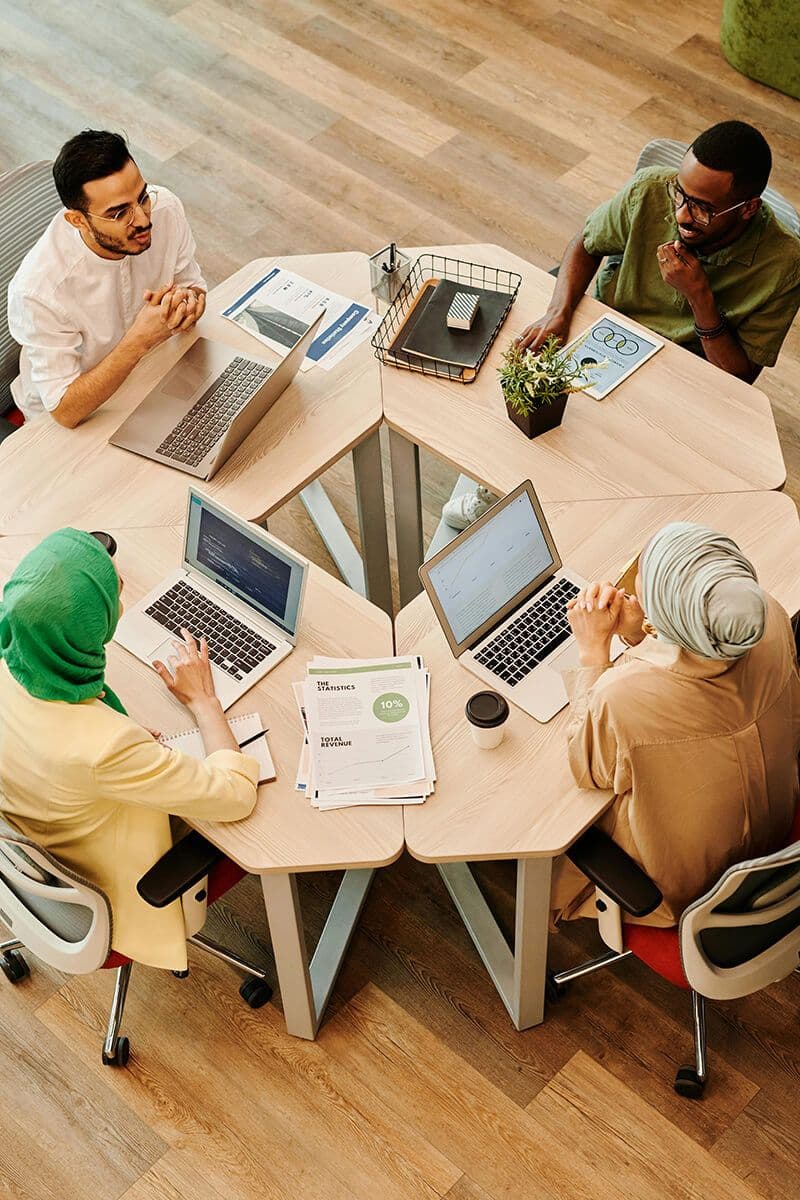 employee resource group members at ERG meeting sitting at office table talking