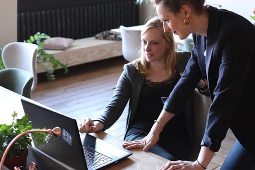 Two women working together on laptop