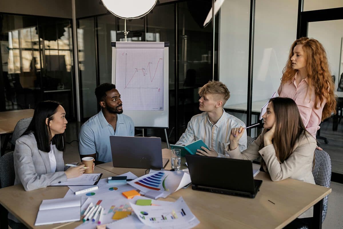 people sitting around a table in a conference room discussing mentorship integrations