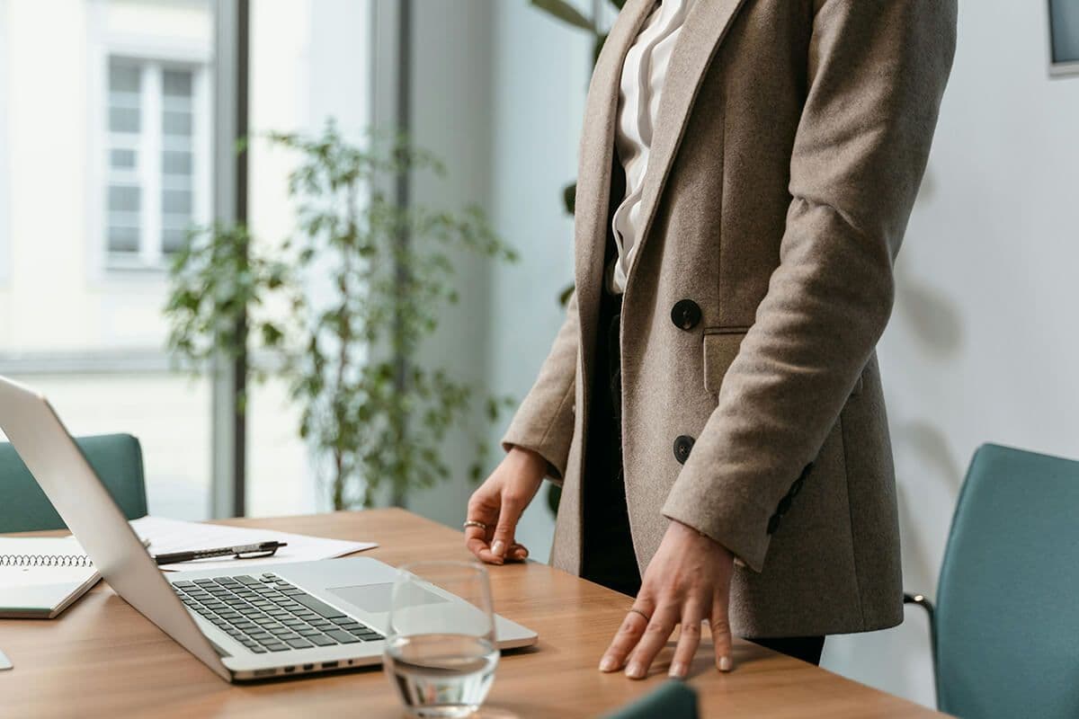 Woman standing in a conference room at her laptop in a leadership style meeting